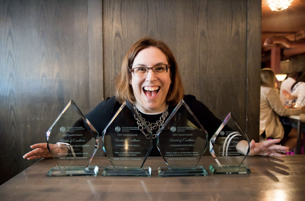 Tammy posing with 4 awards